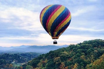 Hot air balloon flying over mountains